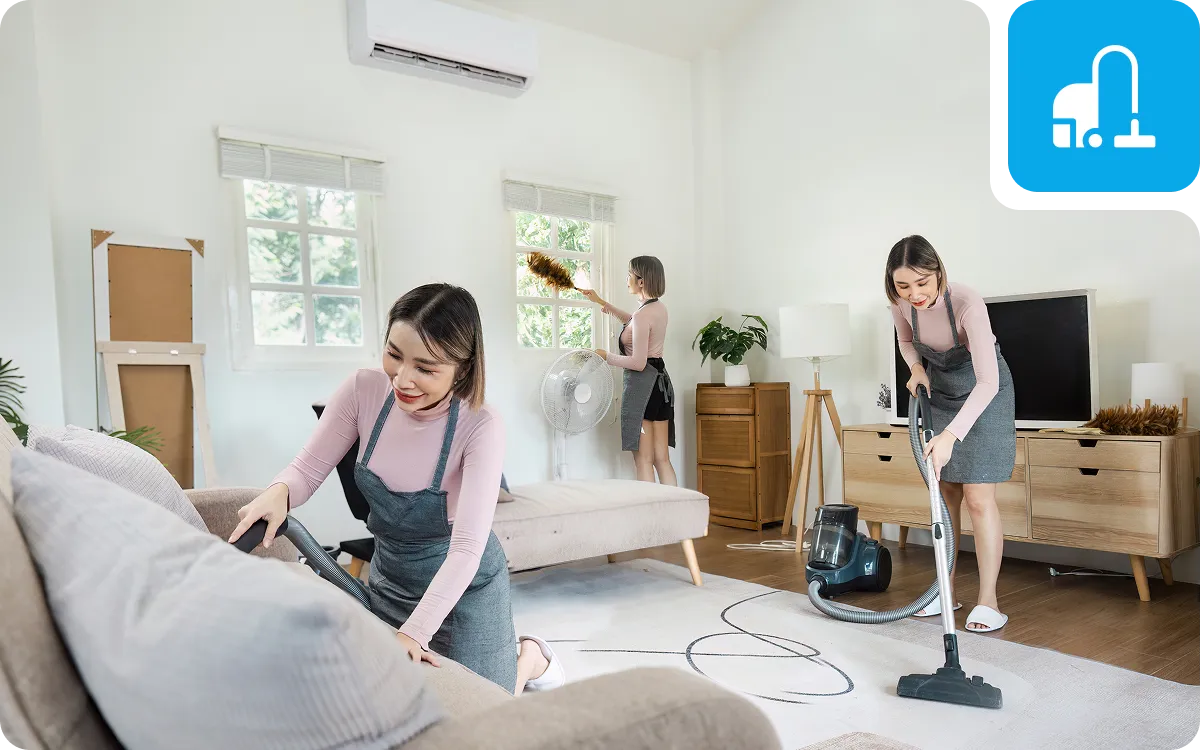 Women cleaning living room with vacuum cleaner.