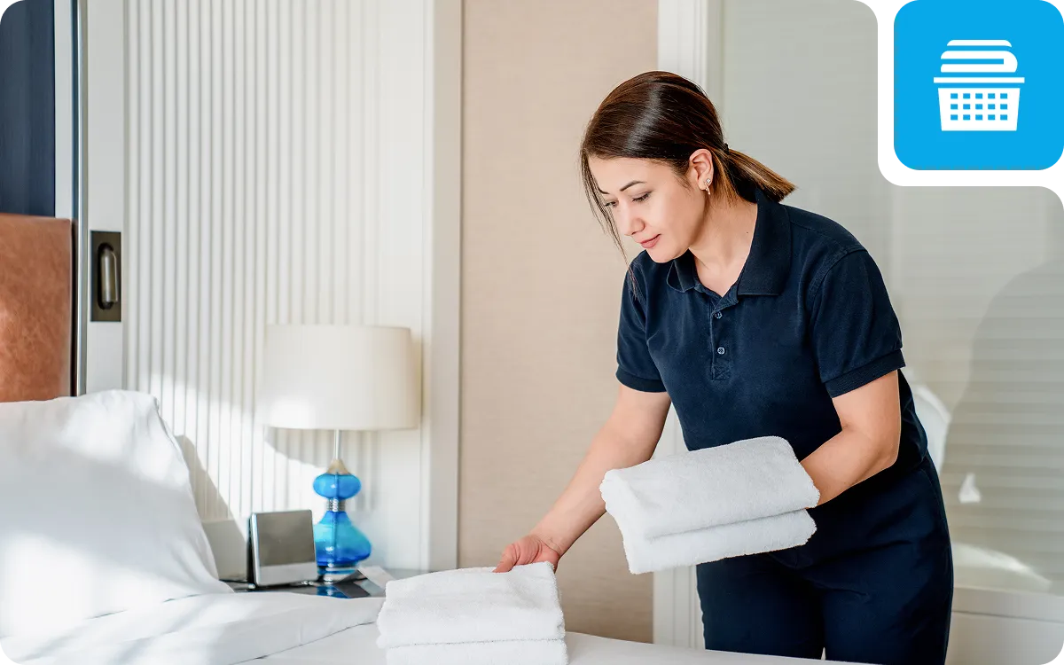 Housekeeper arranging towels on a bed.
